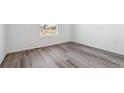 Bright bedroom showcasing wood-look flooring, white trim, and a view of the neighborhood at 4598 Boone Cir, Brighton, CO 80601
