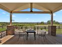 Covered deck area with seating offering views of the surrounding landscaped yard at 1975 Wild Star Way, Castle Rock, CO 80104