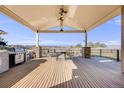 Covered outdoor patio with outdoor kitchen, built in grill and dining set at 1975 Wild Star Way, Castle Rock, CO 80104