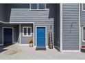 Charming blue front door with a 'Welcome' sign adds curb appeal at 1320 S Monaco St Pkwy # 3, Denver, CO 80224