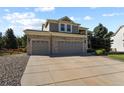 Two-story home with a three-car garage, large driveway, and partial view of the front yard at 11839 Saddleback Ct, Parker, CO 80138