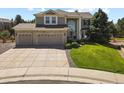 Two-story home featuring a three-car garage and manicured front yard with mature trees at 11839 Saddleback Ct, Parker, CO 80138