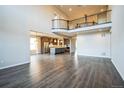 Open-concept living room showcasing hardwood floors and seamless flow into the kitchen at 14221 Ivanhoe St, Thornton, CO 80602