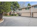Townhome exterior boasts an attached garage, a well-kept lawn, and mature trees in a friendly neighborhood at 6917 E Girard Ave, Denver, CO 80224