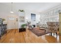 Bright living room featuring hardwood floors, high ceilings, a fireplace, and large windows at 6917 E Girard Ave, Denver, CO 80224