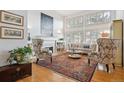 Sunlit living room showcasing hardwood floors, tall windows with shutters, and a cozy fireplace with built-in shelves at 6917 E Girard Ave, Denver, CO 80224