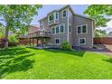 Well-maintained backyard with large grass area and a wood deck perfect for entertaining at 9552 E Caley Cir, Englewood, CO 80111