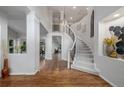 Bright foyer featuring hardwood floors, high ceilings, a curved staircase, and modern chandelier at 9552 E Caley Cir, Englewood, CO 80111