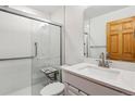 Modern bathroom featuring a walk-in shower with glass door, grab bars, and updated fixtures at 6508 S Garland Way, Littleton, CO 80123