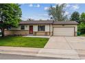 Charming ranch-style home featuring a cozy front porch, well-maintained lawn, and attached garage at 6508 S Garland Way, Littleton, CO 80123