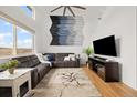 Bright living room with vaulted ceilings, hardwood floors, ample windows, modern furniture, and ceiling fan at 11980 Swansea Dr, Parker, CO 80134