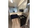 Modern kitchen featuring stainless steel appliances, light grey cabinets, and dark blue lower cabinets at 2280 S Jasper Way # A, Aurora, CO 80013