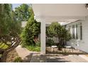 Covered porch with brick pillar, seating, and views of the landscaped front yard at 950 Everett St, Lakewood, CO 80215