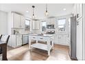 Bright kitchen with white cabinets, stainless steel appliances, island, and hardwood floors at 10031 Town Ridge Ln, Lone Tree, CO 80124