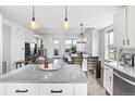 Open-concept kitchen view to dining and living area with modern lighting and hardwood floors at 10031 Town Ridge Ln, Lone Tree, CO 80124