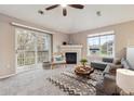 Cozy living room with a fireplace, a sliding glass door to a balcony, and a large window at 3262 E 103Rd Dr # 1806, Thornton, CO 80229