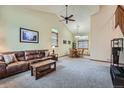 Open-concept living room featuring vaulted ceilings, neutral carpeting, and lots of natural light at 4858 S Queen St, Littleton, CO 80127