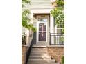 Charming home entrance features a brick staircase, black iron railing, and a green front door with sidelight at 9369 Longs Peak Dr, Commerce City, CO 80640