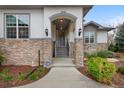 Inviting front entrance with stone accents, covered porch, and manicured landscaping at 8155 W Tennessee Dr, Lakewood, CO 80226