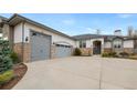 Home featuring a three-car garage, stone accents, and a spacious driveway at 8155 W Tennessee Dr, Lakewood, CO 80226