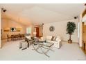 Bright living room boasts vaulted ceilings and an open layout to the dining area at 13990 E Chenango Dr, Aurora, CO 80015