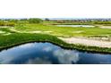 Picturesque view of a golf course with a tranquil pond, vibrant greenery, and sand traps at 3940 Malaya St, Denver, CO 80249