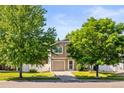 Charming two-story home with well-manicured lawn and mature shade trees at 18672 E Chaffee Pl, Denver, CO 80249