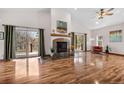 Bright living room featuring a fireplace, wood floors, and sliding door with access to the deck at 459 Virginia Ave, Palmer Lake, CO 80133