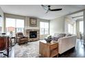 Cozy living room featuring hardwood floors, a stone fireplace, and a comfortable seating area at 15160 W Iliff Pl, Lakewood, CO 80228