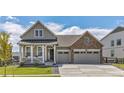 Charming two-story home featuring a covered porch, two-car garage, and well-maintained lawn at 5128 Preserve Pl, Firestone, CO 80504