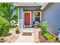 Inviting front porch with a red door, plants, and cozy seating, perfect for relaxing at 165 Montgomery Dr, Erie, CO 80516