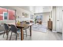 Open-concept living room with hardwood floors, modern furniture, and a dining area at 5760 N Boston St, Denver, CO 80238