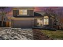 Charming two-story home featuring a brick facade, manicured lawn, and attached two-car garage at 5821 S Quatar Cir, Centennial, CO 80015