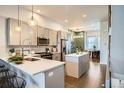 Modern kitchen featuring sleek countertops, stainless steel appliances, island with bar stools, and hardwood floors at 1919 W 46Th Ave # 3, Denver, CO 80211
