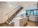 Open-concept kitchen featuring a center island, modern appliances, plenty of storage, and a staircase nearby at 1919 W 46Th Ave # 3, Denver, CO 80211