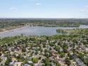 Expansive aerial view showcasing the neighborhood, nearby lake, and recreational areas with trees and green spaces at 4858 S Quintero Cir, Aurora, CO 80015