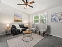 Comfortable living room with neutral walls, carpet, a ceiling fan, a large window, and cozy seating at 4858 S Quintero Cir, Aurora, CO 80015