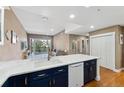 Bright open-concept kitchen with white counters and dark cabinetry overlooking the living area at 6000 W Floyd Ave # 214, Denver, CO 80227