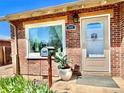 Charming brick home featuring a welcoming front door, large window, and a well-manicured garden at 1965 Havana St, Aurora, CO 80010
