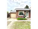 Charming brick home featuring a well-kept lawn, flower bed, and single car garage at 1965 Havana St, Aurora, CO 80010