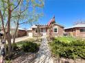 Quaint home with a charming pergola over the walkway, lush greenery, and an American flag at 1965 Havana St, Aurora, CO 80010