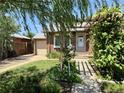 Charming brick home with a well-manicured front yard, pergola, and a detached single-car garage at 1965 Havana St, Aurora, CO 80010