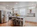 Bright, modern kitchen with white cabinets, stainless steel appliances, and a rustic island at 8367 Devinney St, Arvada, CO 80005