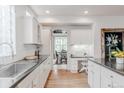 Bright kitchen features white cabinets, stainless steel sink, and a built-in desk area at 8367 Devinney St, Arvada, CO 80005