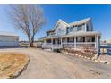 Stately two-story home featuring an expansive wraparound porch and detached garage, perfect for country living at 2257 Deerpath Rd, Franktown, CO 80116