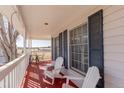 Relaxing porch with white rocking chairs and side table, providing serene outdoor living space at 2257 Deerpath Rd, Franktown, CO 80116