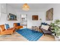 Stylish living room with leather chairs, hardwood floors, and decor at 211 E Emma St, Lafayette, CO 80026