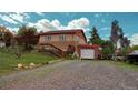 A two-story brick home with a detached garage and a gravel driveway at 5870 Nelson Ct, Arvada, CO 80004