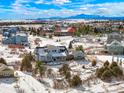 Scenic aerial view of community homes with mountain views on a sunny, snow-filled day at 7186 Weaver Cir, Castle Rock, CO 80104