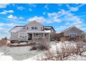 Charming two-story home with a covered porch, snow on the ground, and a separate garage at 7186 Weaver Cir, Castle Rock, CO 80104